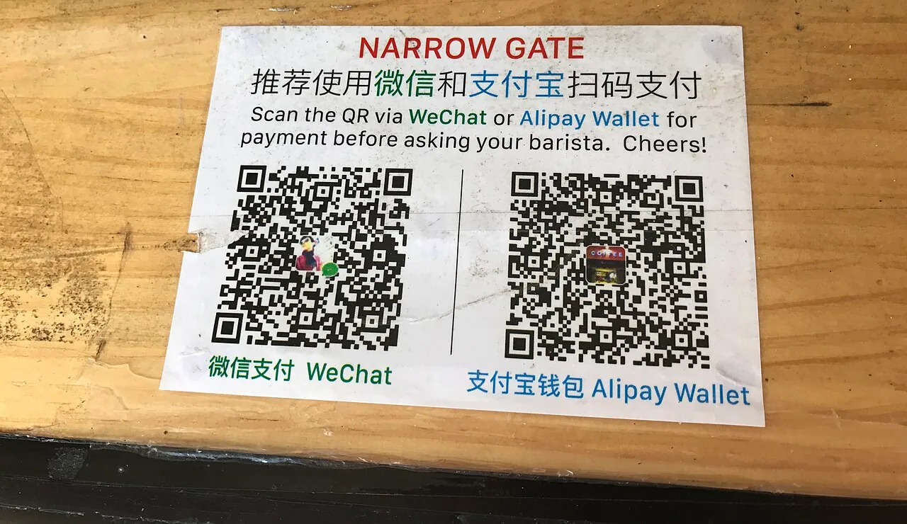 WeChat Pay and Alipay QR codes displayed at a shop counter in China