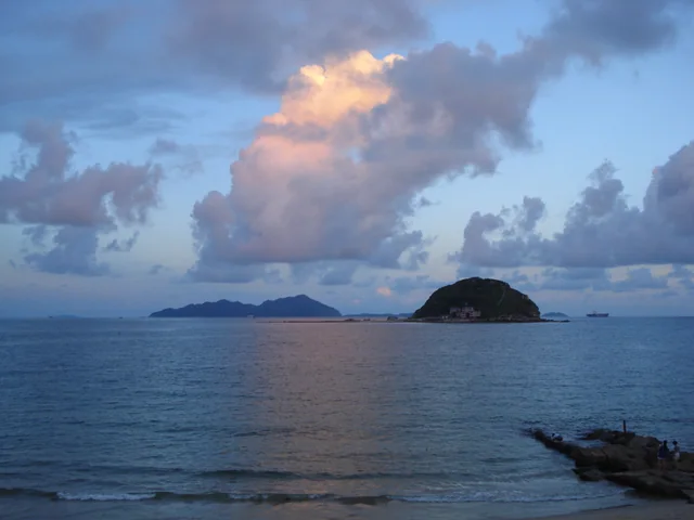 Clouds lit by sunset over the water and offshore islands at Xichong