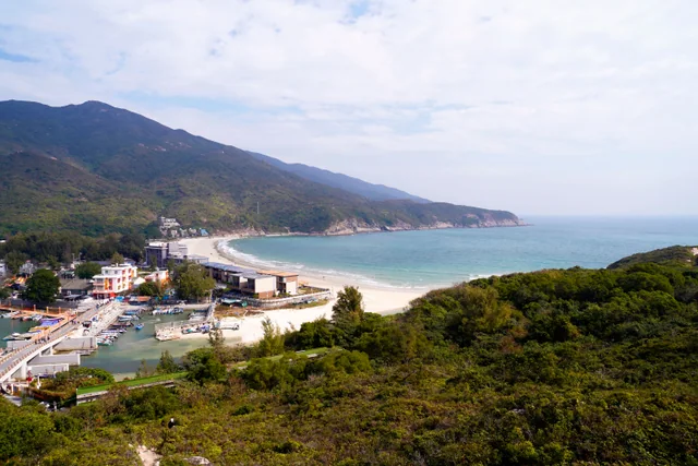 Dongchong Beach and its curved bay below green hills on the Dapeng Peninsula