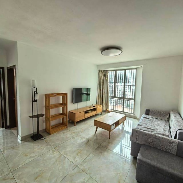 Living room with a grey sofa, wooden coffee table and balcony doors in Alex's Haidianju listing photo