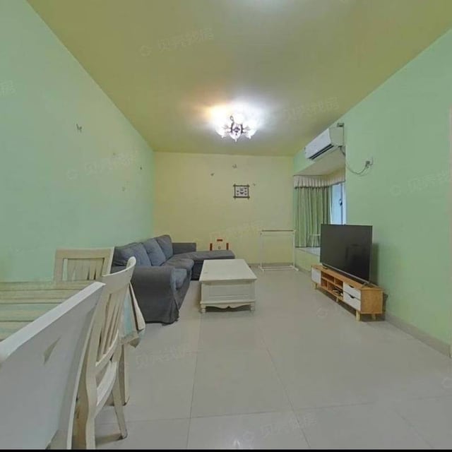 Living room with green walls, grey sofa and white dining furniture in the Qianhai Mingzhu advertiser's photo