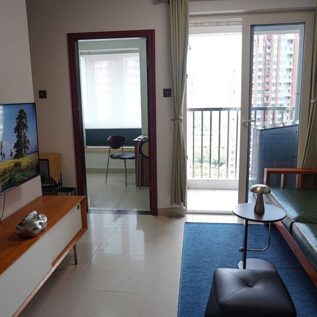 Living room with a blue rug, balcony doors and an adjoining room in Ray's Songping Village III West listing photo