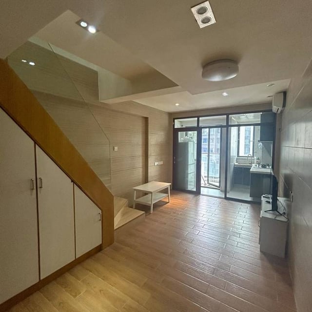 Living area with wooden flooring, an internal staircase and glazed doors in the Qiyou Jiayuan listing gallery