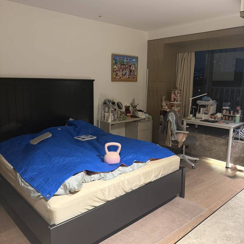Bedroom with a dark bed frame, blue bedding and a desk in the Shuangxi · Times Road advertiser's gallery