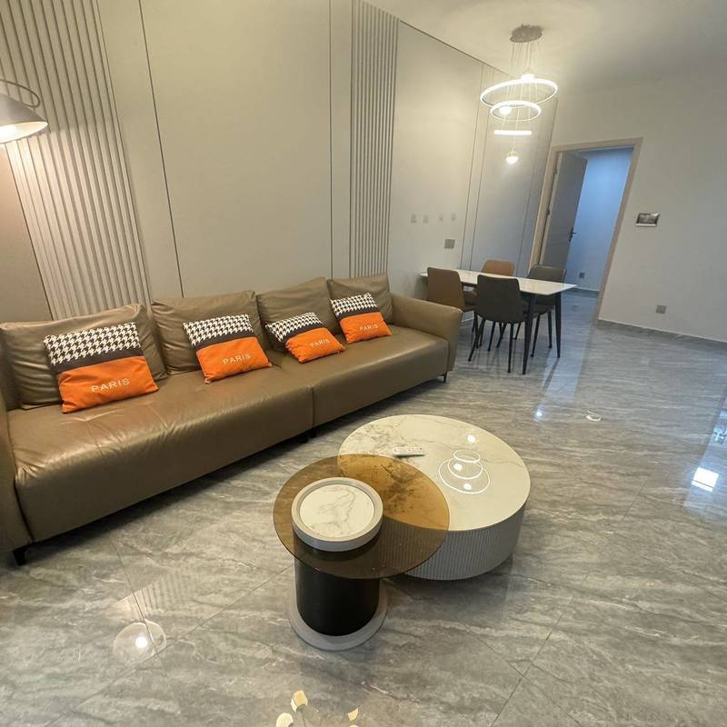 Living and dining room with a sofa and round coffee table in the Xintian Shixia Mingyuan advertiser gallery